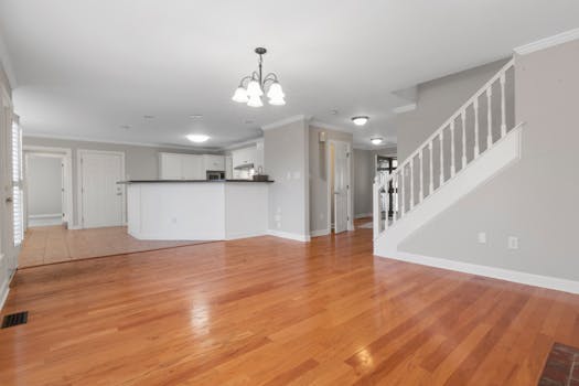Bright and airy open floor plan with hardwood flooring and white kitchen cabinets.