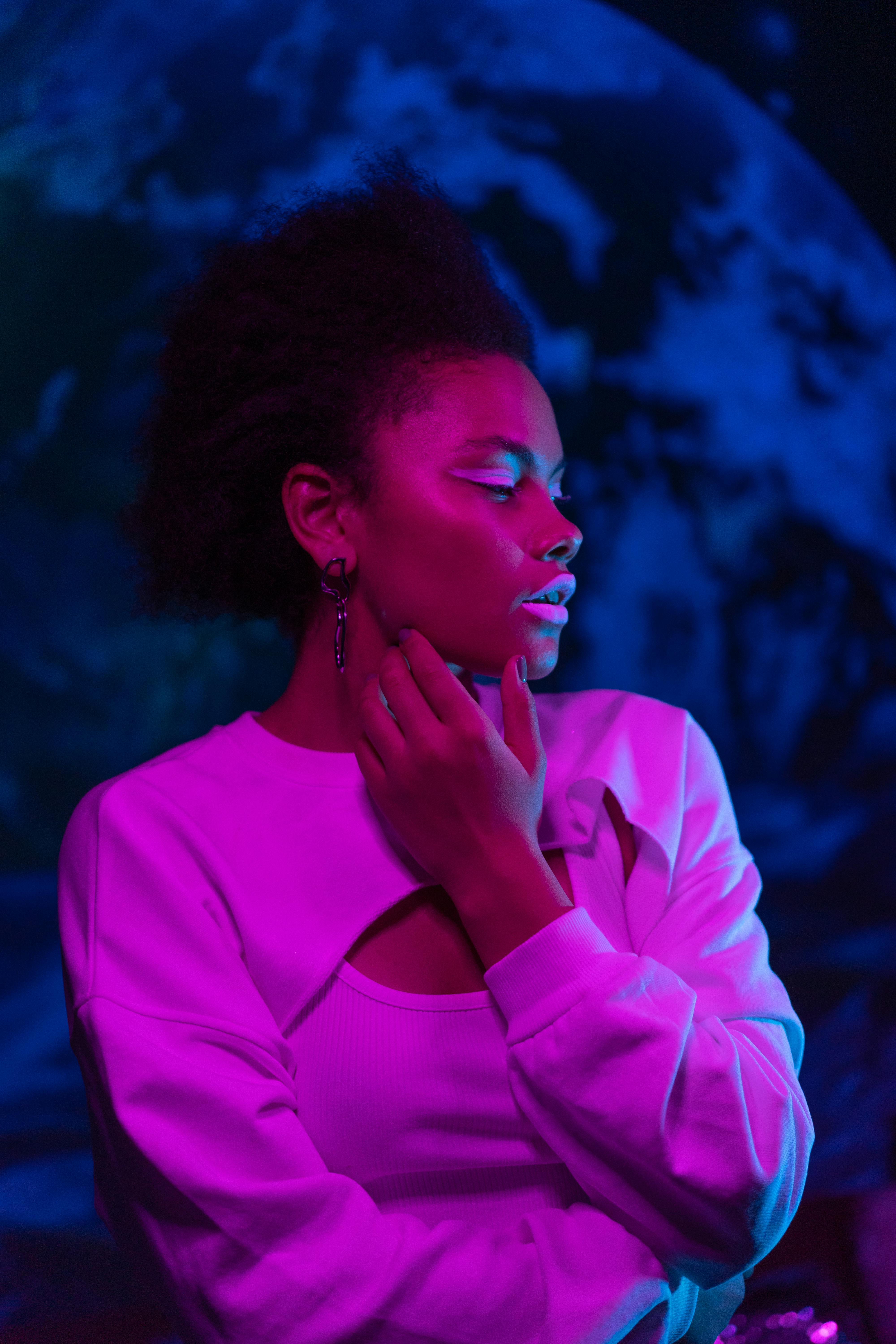 Artistic portrait of a woman with pink and blue neon lighting, evoking a modern and stylish mood.