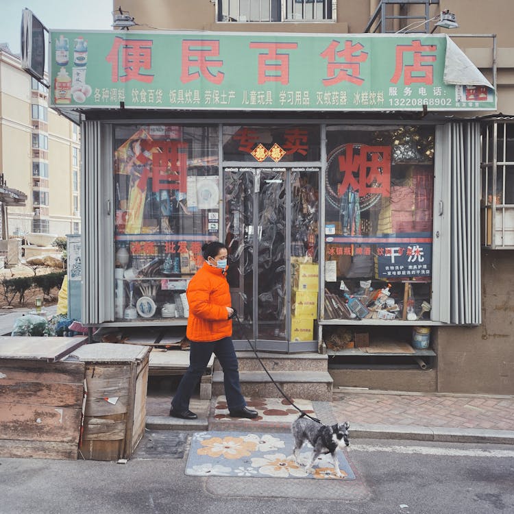 Woman Walking Dog Near Store