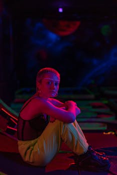 Vibrant portrait of a woman with neon makeup in a futuristic setting, highlighting modern fashion.