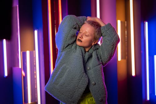 Woman in Gray Fur Coat Standing beside Neon Lights