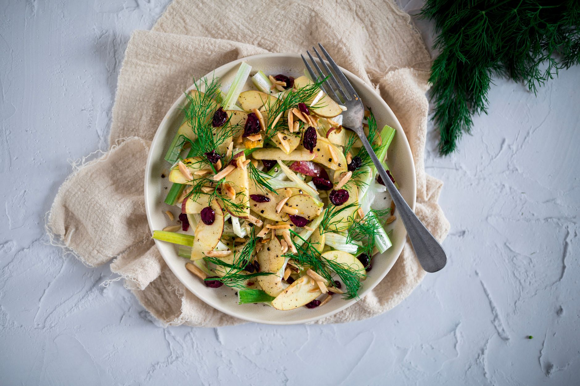 Overhead shot of a colorful seasonal vegetable-forward plate on a ceramic dish with natural texture and soft shadows.