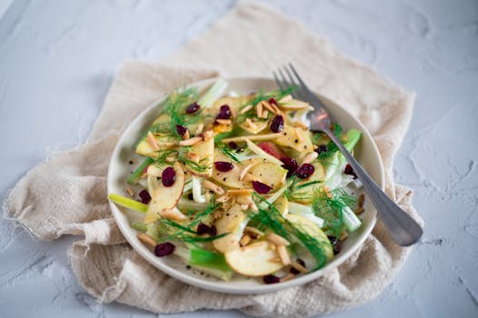 A healthy apple fennel salad with dried cranberries and almonds, perfect for a light meal.
