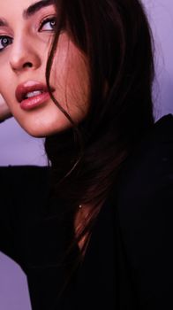 Artistic close-up portrait of a young woman with striking eyes and mystery vibe.