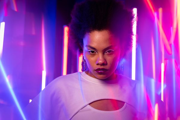 Close-up portrait of a woman lit by neon — photo by Mikhail Nilov on Pexels