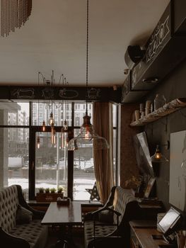 Warm and inviting cafe interior featuring plush armchairs and vintage lighting.