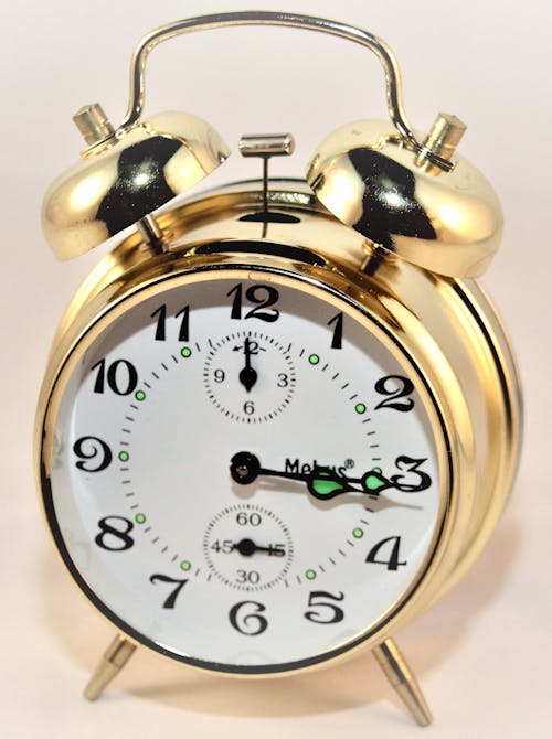 Brass-colored Alarm Clock at 3:15
