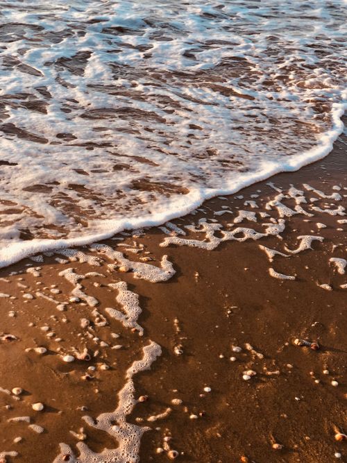 Free Captivating view of gentle waves and sea foam on Bat Yam Beach during the day. Stock Photo