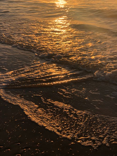 Free A captivating sunset reflecting golden hues over the gentle waves at Bat Yam Beach, Israel. Stock Photo