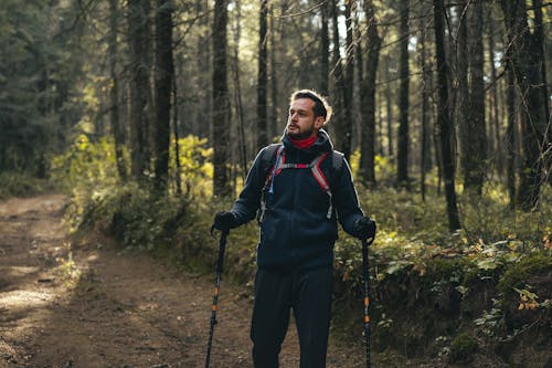 A Man Hiking on the Dirt Path in the Forest