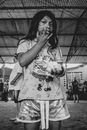 Ethnic teen girl licking fingers while eating in shelter