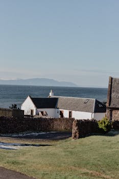 Charming white house by the sea in Scotland, offering coastal tranquility.