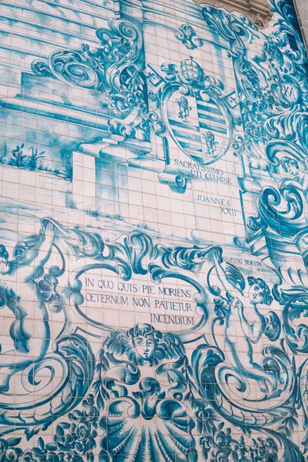 Detailed close-up of intricate blue azulejo tiles with ornate designs and Latin text.