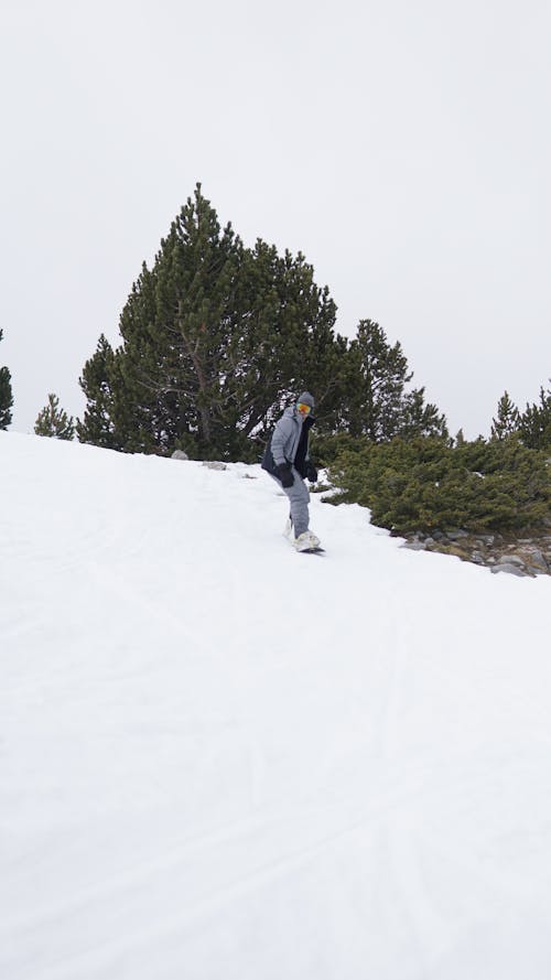 Man riding a Snowboard going Down the Slope 