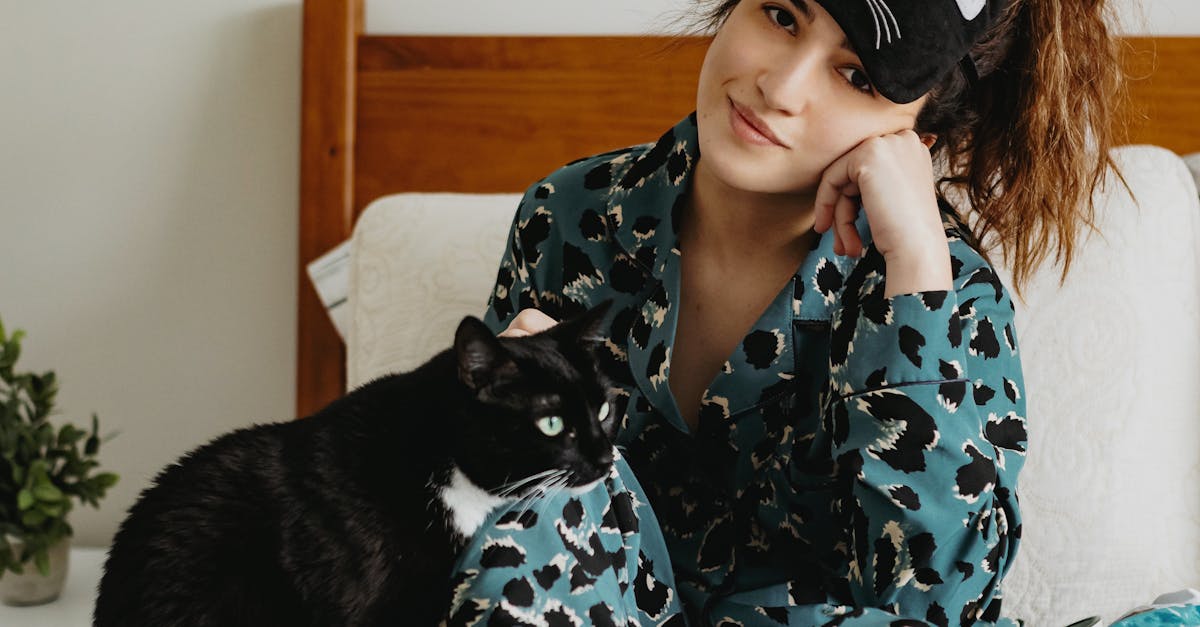 Young woman in sleepwear with cat on bed