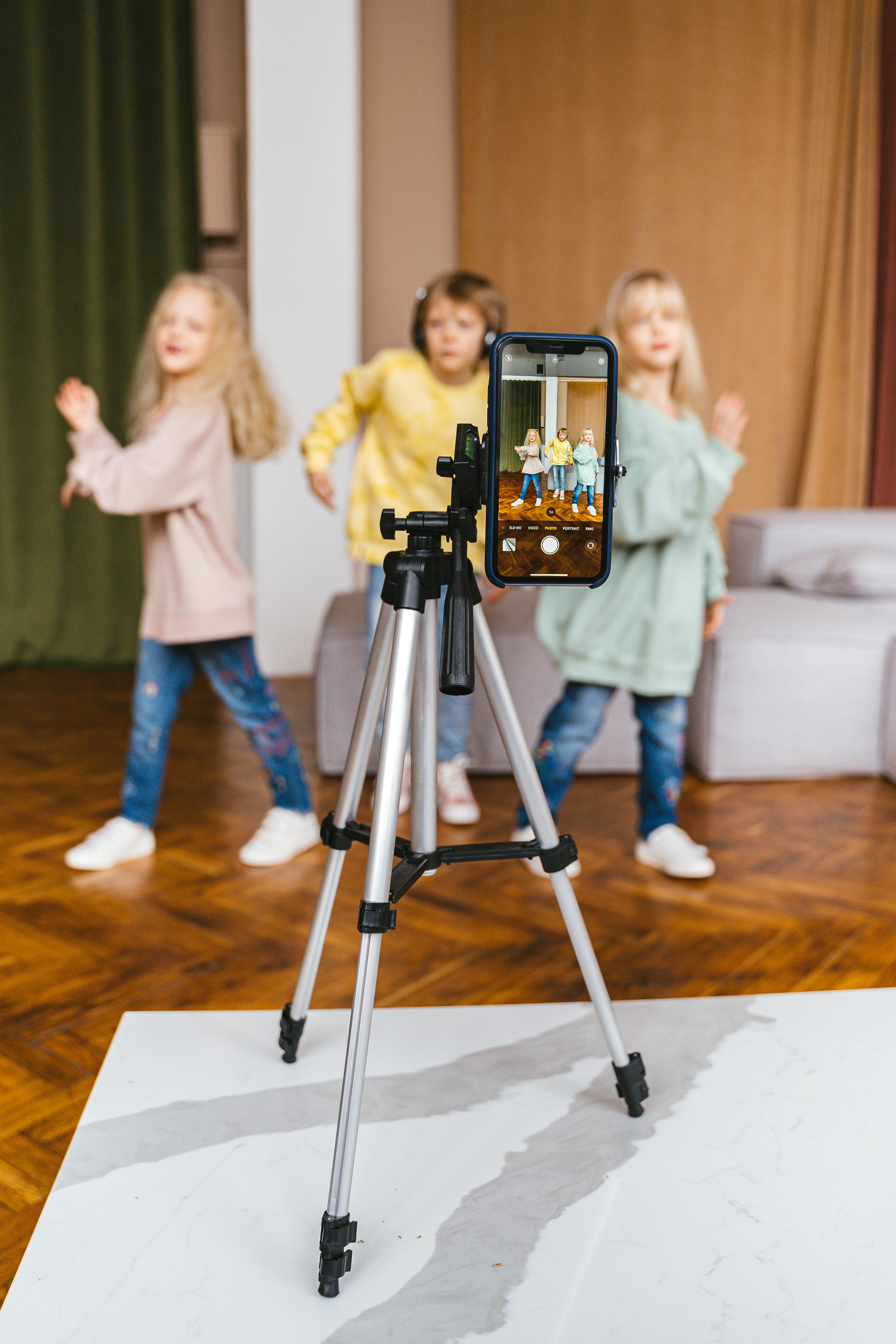 Young Girl Recording Herself with a Phone on a Tripod and Showing a Book to  the Camera · Free Stock Photo