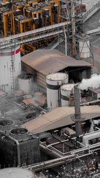 Bird's-eye view of intricate machinery and pipework at an industrial factory, showcasing production activity.