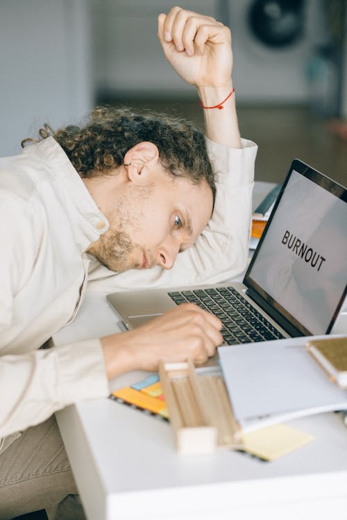 Overworked Employee lying in front of Laptop 