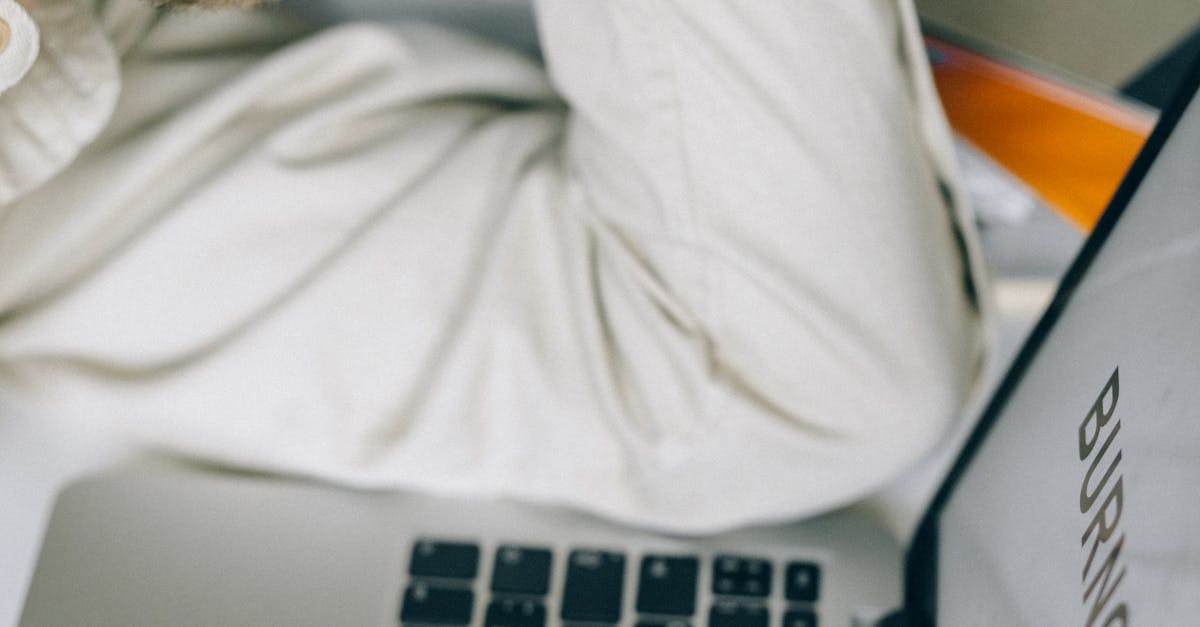 Photo by Nataliya Vaitkevich Tired employee leaning on laptop displaying 'Burnout', illustrating workplace stress.