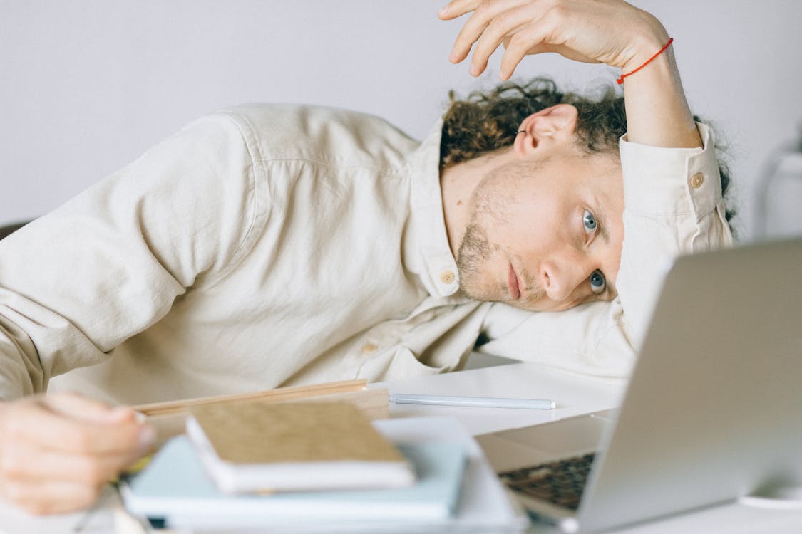 Free Overworked Employee lying in front of Laptop  Stock Photo