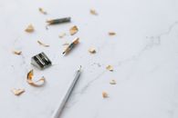 Close-up Photo of Sharpener and Pencil on Marble Surface