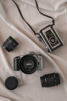 Flat lay of vintage and modern cameras with lenses on fabric background.. flat, vintage, modern