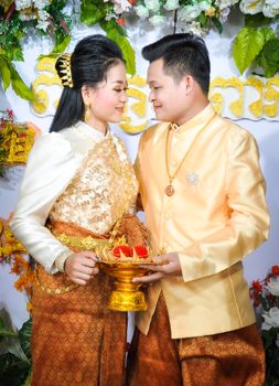 Happy couple in traditional attire celebrating their wedding day with a special ceremony.
