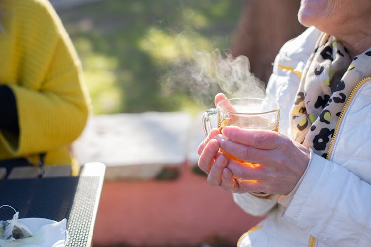 A Person Holding A Cup Of Hot Tea 