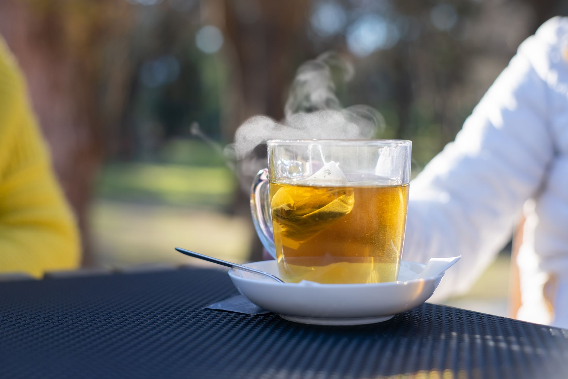 Steaming herbal tea in a clear glass cup on a wooden table Steaming herbal tea in a clear glass cup on a wooden table