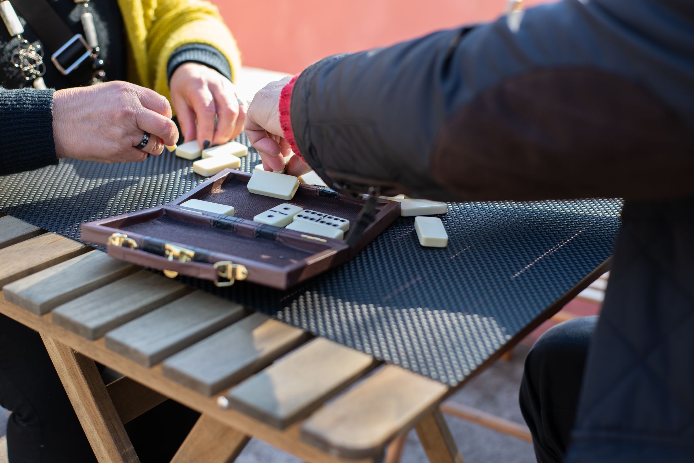 A family playing dominoes outdoors on a long afternoon