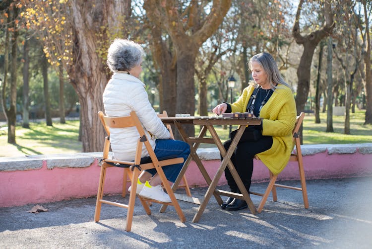 Elderly Woman Playing Domino In The Forest Park