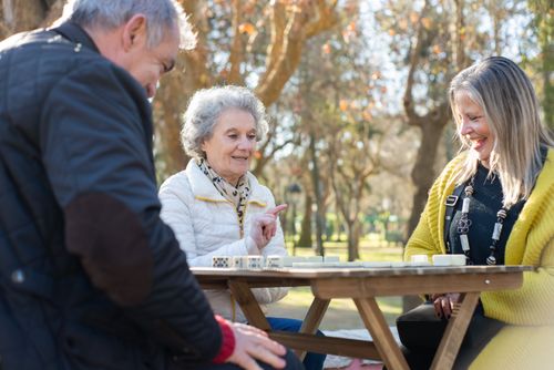 Free Elderly friends playing dominoes at a park in Portugal, outdoors and enjoying leisure time. Stock Photo