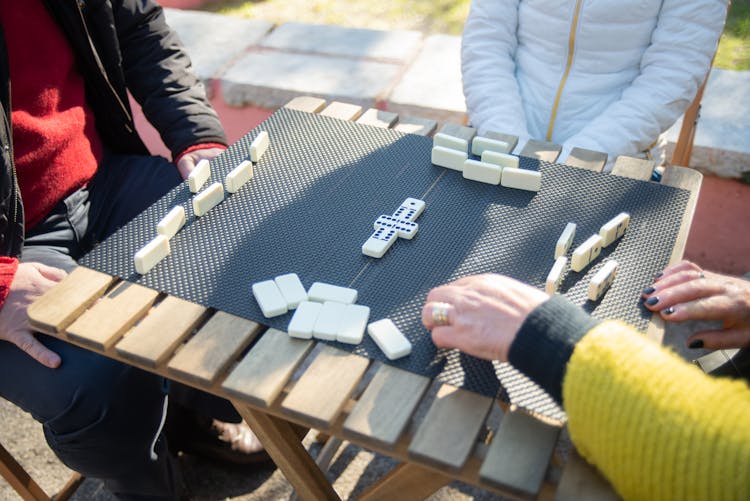 A Group Of People Playing Dominoes