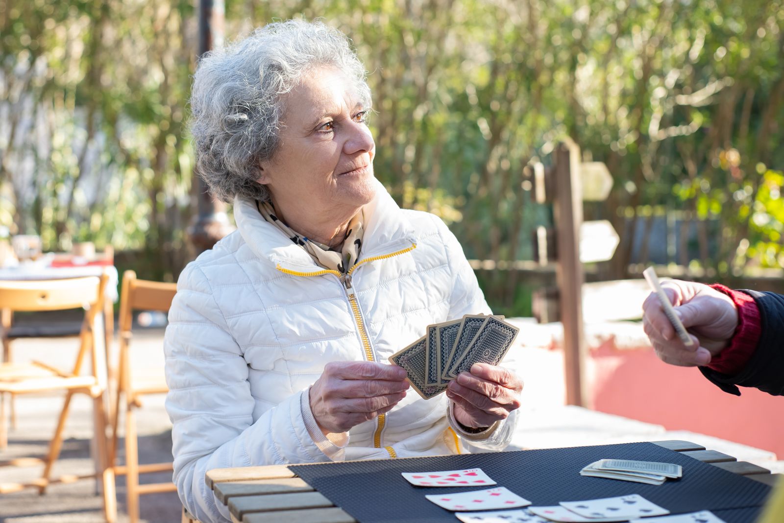 Personne âgée jouant aux cartes en extérieur