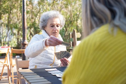 Free Two senior women enjoying a card game outside in Portugal on a sunny day. Stock Photo