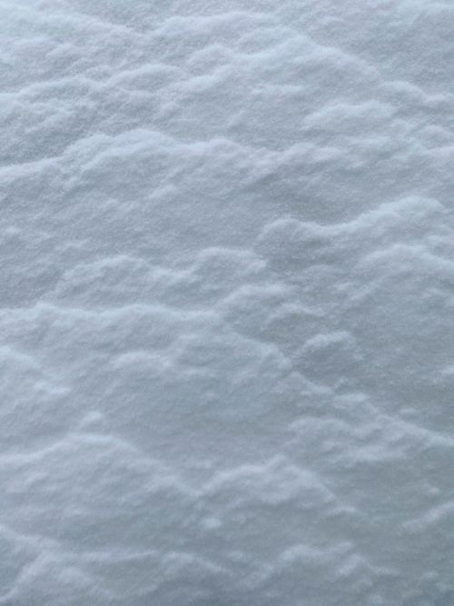 Free Detailed close-up of snow surface displaying delicate textures and patterns, evoking a serene winter scene. Stock Photo