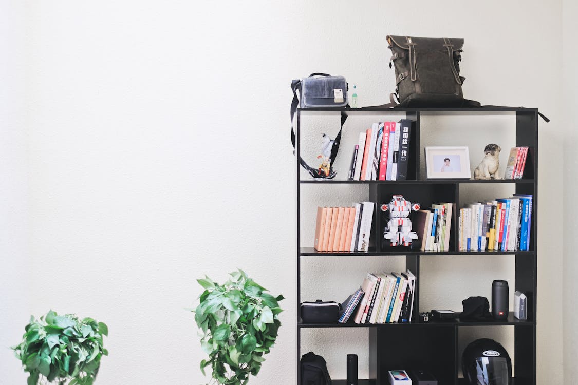 Books and Speakers on Black Wooden Shelf