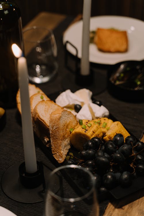 
A Close-Up Shot of a Food on a Plate beside a Lighted Candle