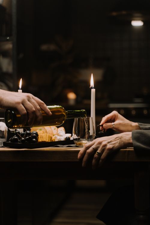 Free Romantic candlelit dinner with wine and cheese being served at a cozy table. Stock Photo