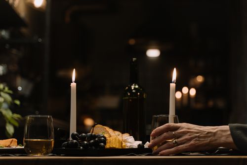 Free Intimate candlelit dinner setup with wine and snacks, creating a warm ambiance. Stock Photo