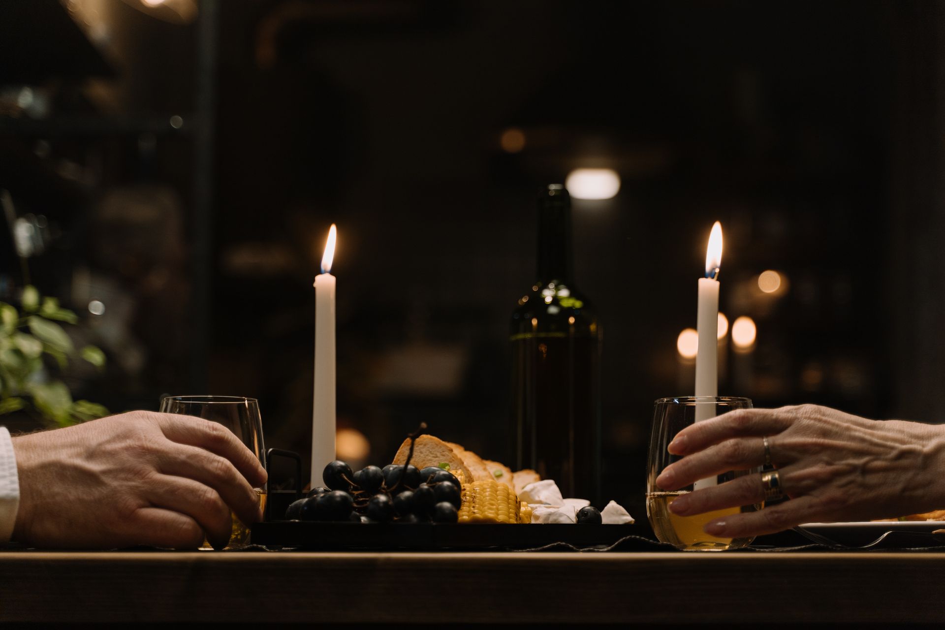 People Getting the Glasses of Drinks on the Table with Lighted Candles and Mouthwatering Food