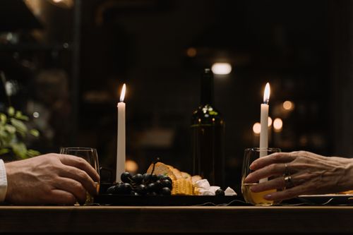Free Intimate dinner setup with wine, cheese, and candles on a wooden table. Stock Photo