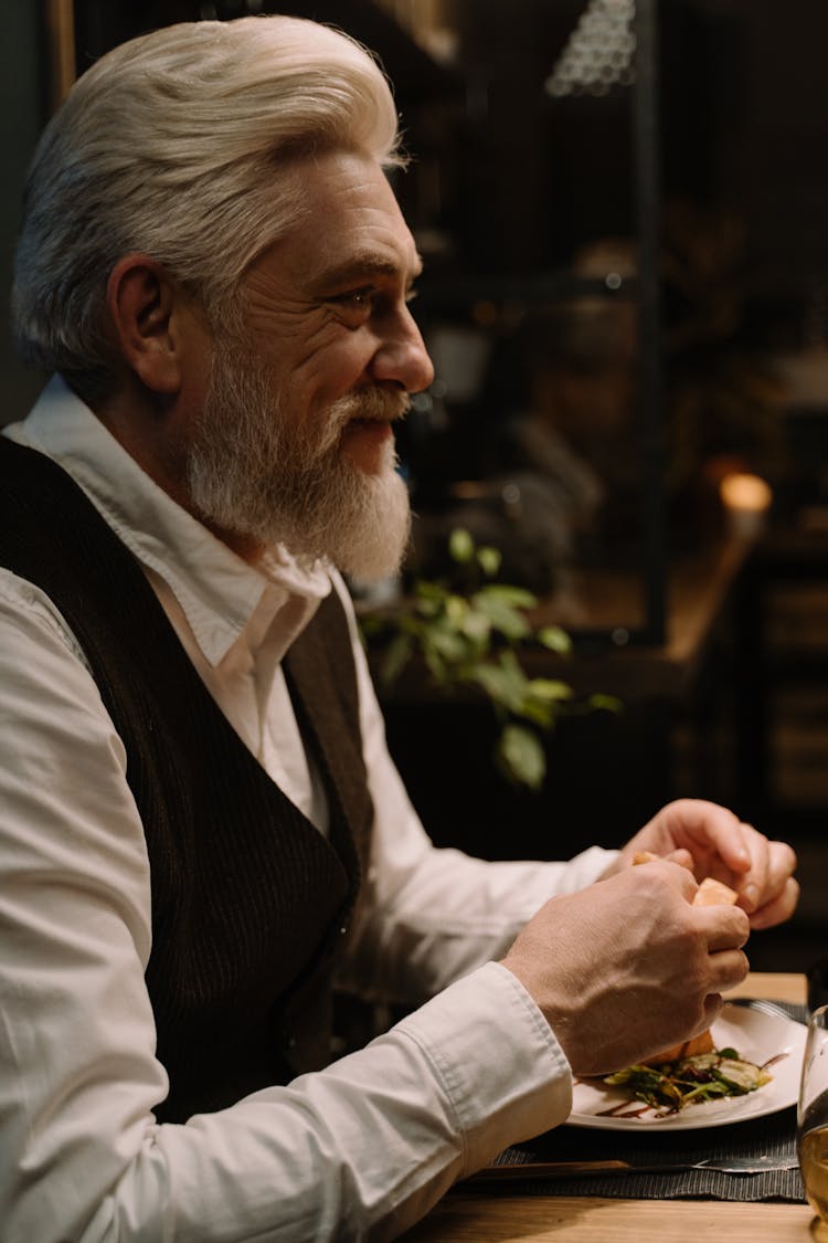 Side View Of A Man Eating On The Table