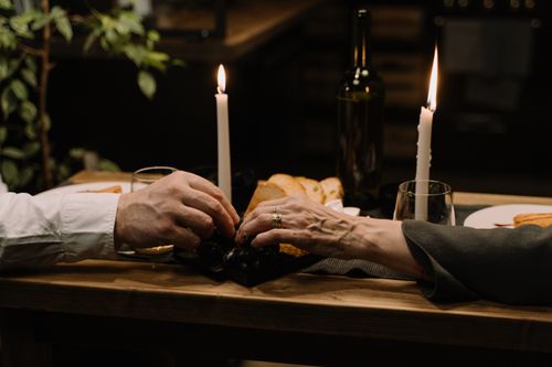 Free A cozy romantic dinner setting with candles, wine, and bread, highlighting intimacy and warmth. Stock Photo