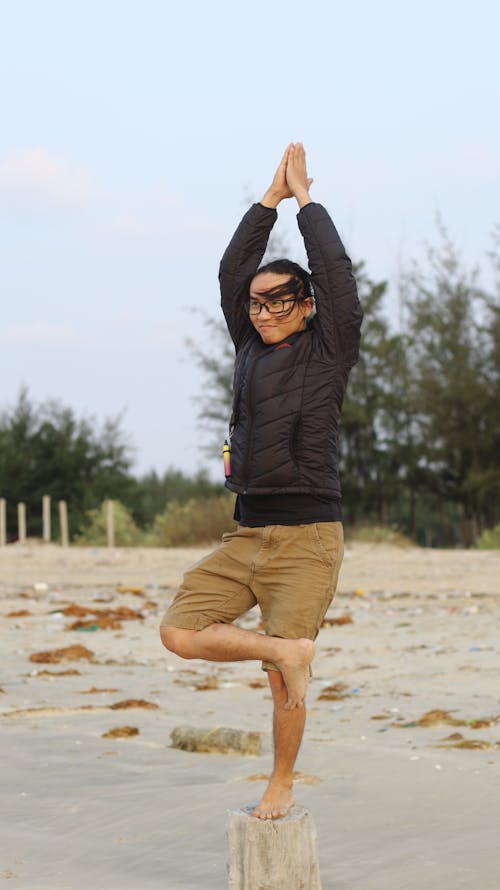 Man in Black Coat and Brown Short in Yoga Position