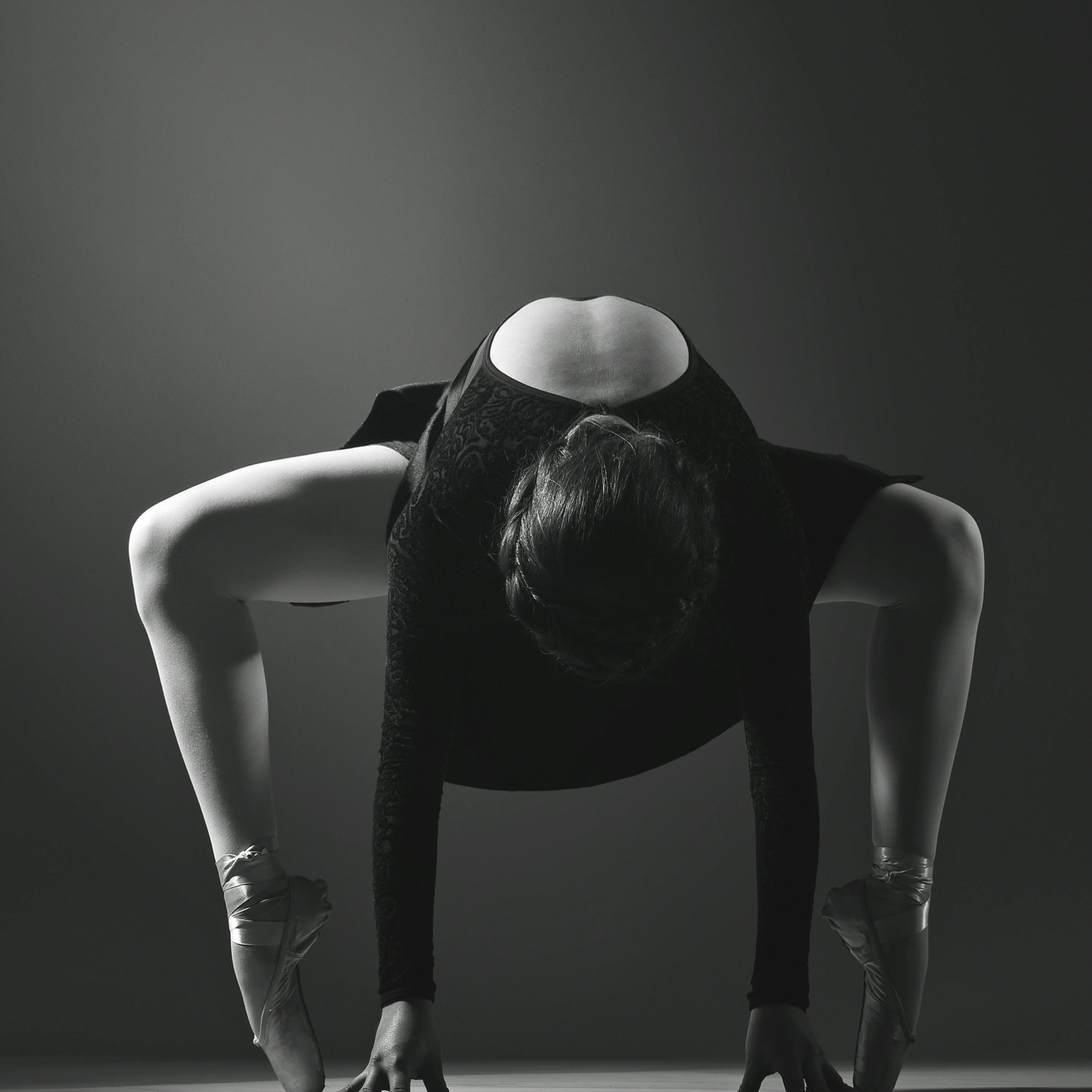 Free Black and white photo of a ballet dancer in a dramatic pose, showcasing elegance and strength. Stock Photo