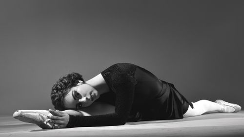 Free Black and white photo of a ballerina in a split, showcasing grace and strength. Stock Photo