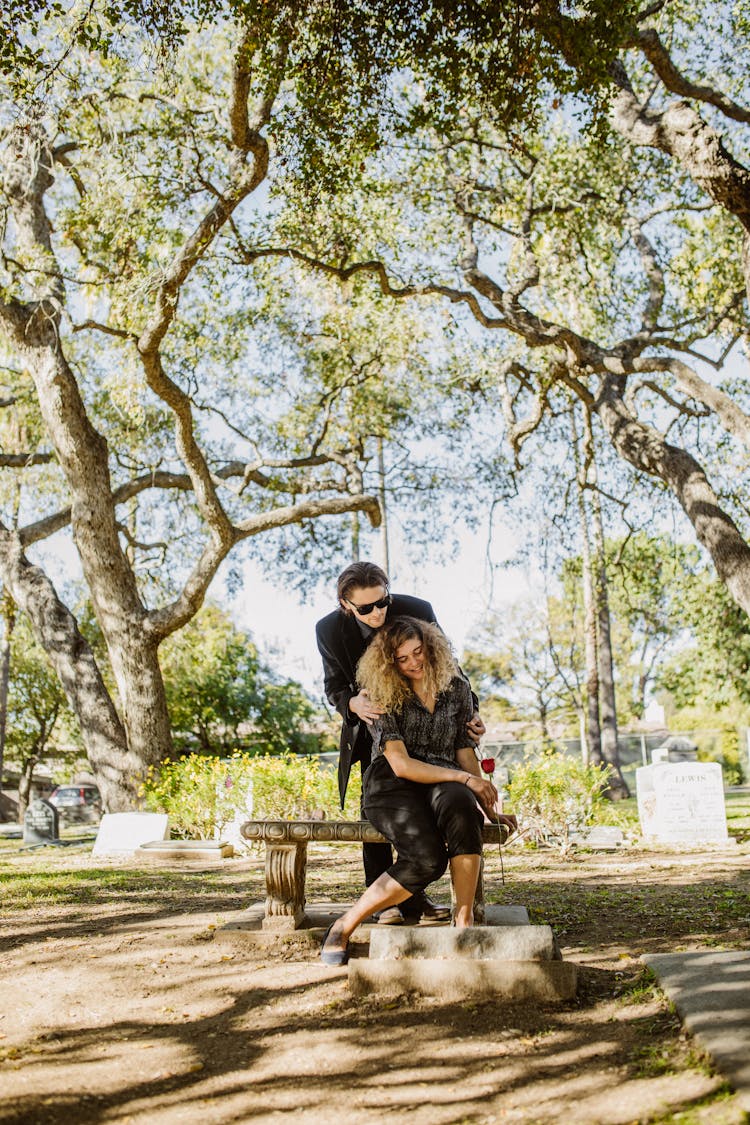 Couple Mourning Beside Tombstone