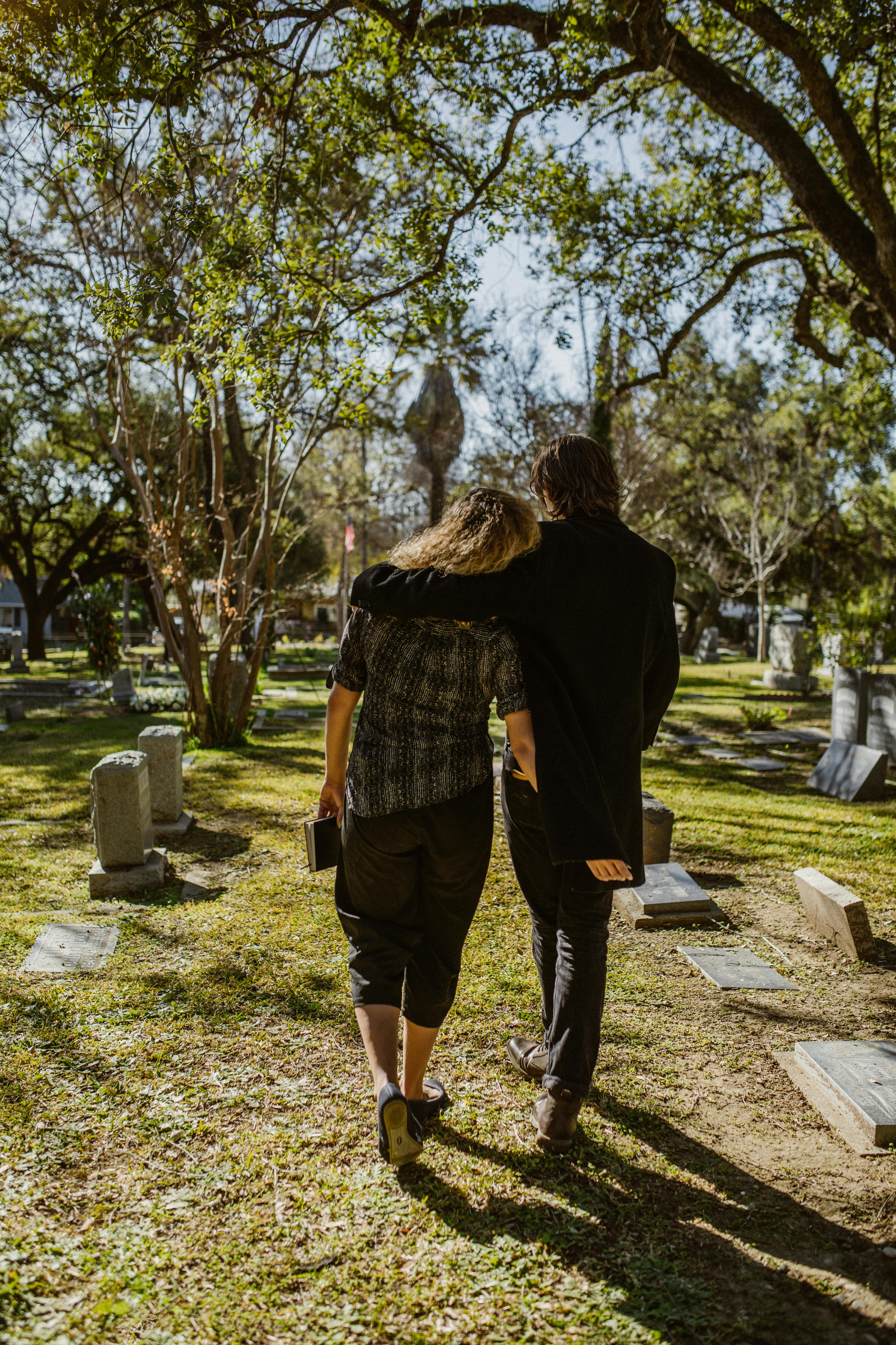 backview of a couple walking on a cemetery