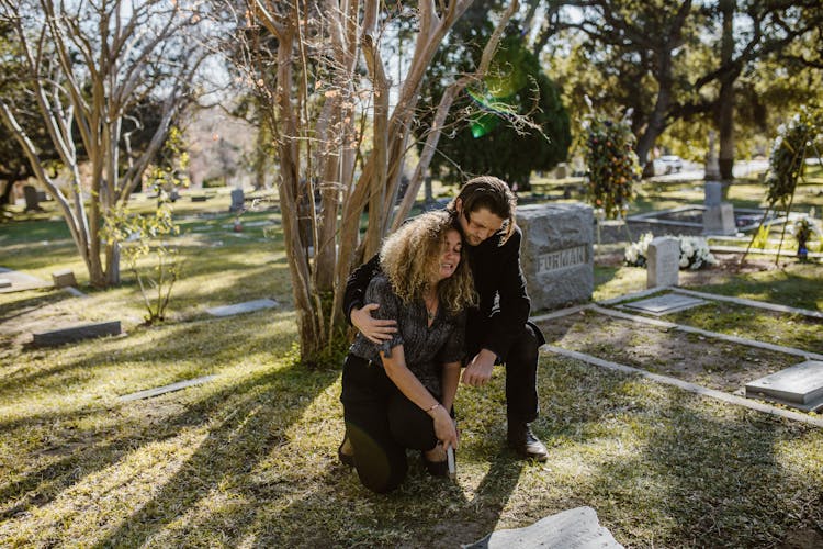 A Man And Woman Crying In The Cemetery